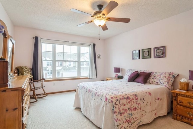 carpeted bedroom featuring a textured ceiling and ceiling fan