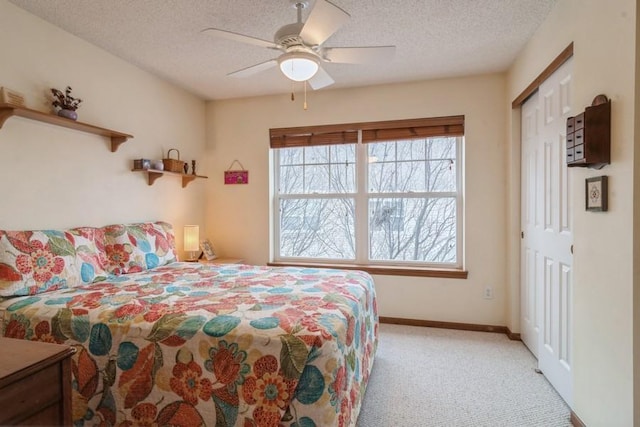 carpeted bedroom featuring a textured ceiling, ceiling fan, and a closet