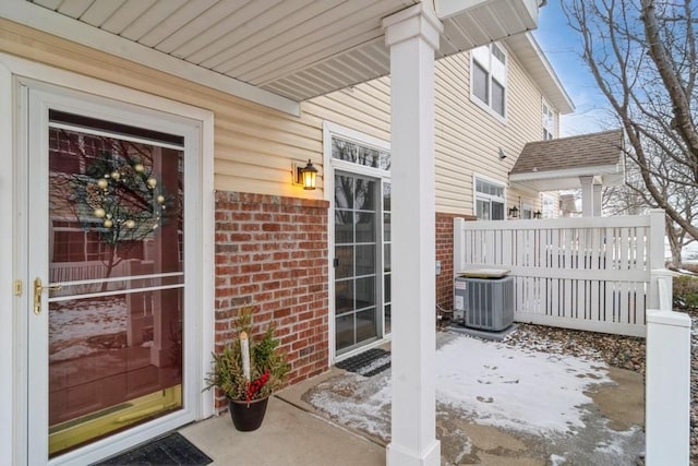 snow covered property entrance featuring cooling unit