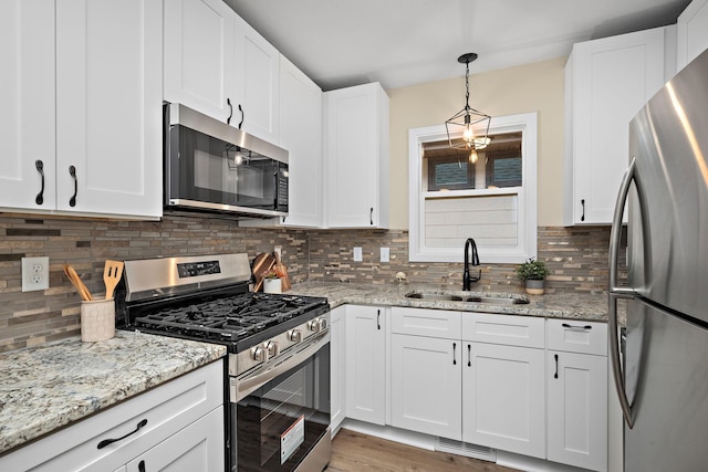 kitchen with decorative backsplash, stainless steel appliances, white cabinetry, and sink