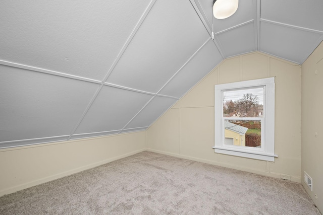 bonus room with carpet floors and vaulted ceiling