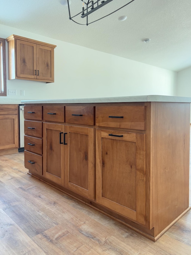 kitchen with brown cabinets, light countertops, and light wood-style floors