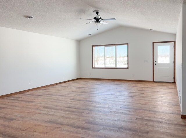 unfurnished living room with light wood-style floors, vaulted ceiling, a textured ceiling, and ceiling fan