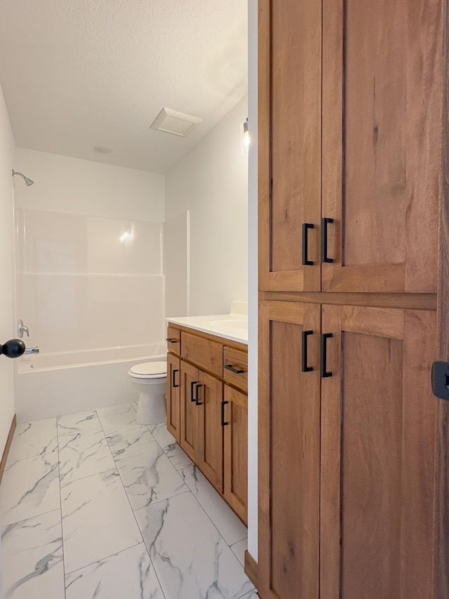 full bath with a textured ceiling, shower / bathtub combination, toilet, vanity, and marble finish floor