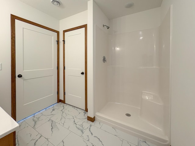 full bathroom featuring marble finish floor, a shower stall, and visible vents