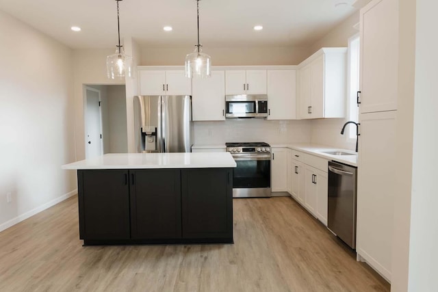 kitchen with stainless steel appliances, a kitchen island, and white cabinetry