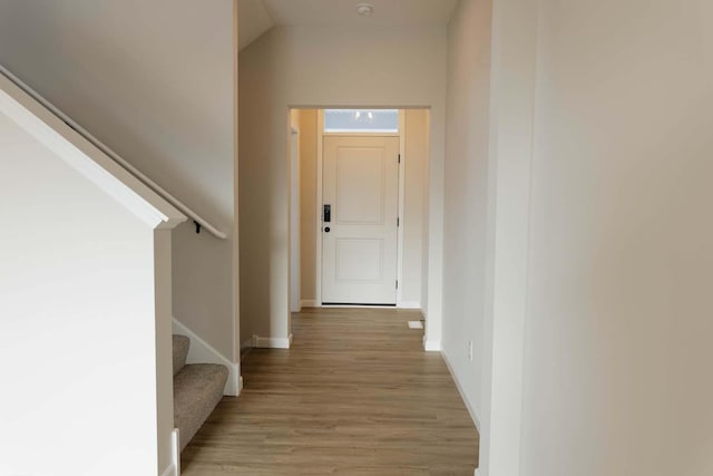 hall featuring light hardwood / wood-style flooring and lofted ceiling