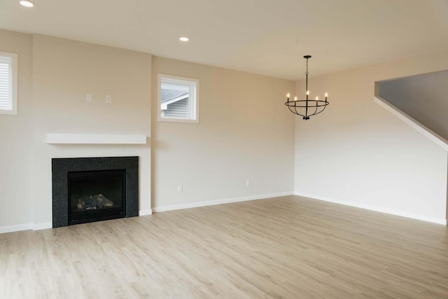 unfurnished living room featuring hardwood / wood-style floors and a notable chandelier