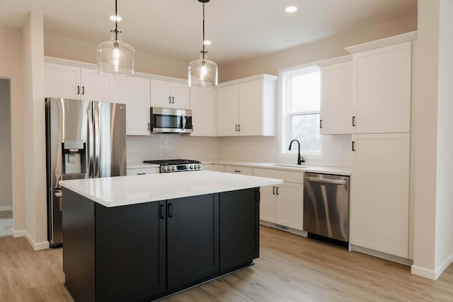 kitchen with white cabinetry, a kitchen island, hanging light fixtures, and appliances with stainless steel finishes