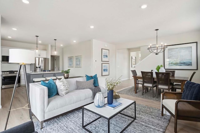 living room with an inviting chandelier and light hardwood / wood-style flooring