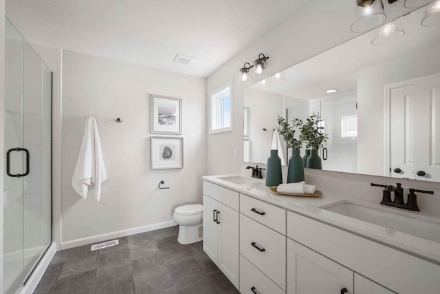 bathroom featuring a sink, a stall shower, and toilet