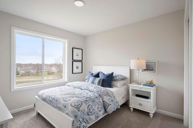 bedroom with baseboards and dark colored carpet