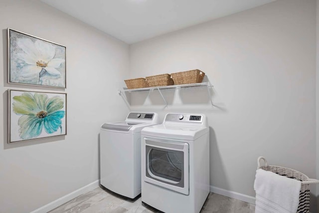laundry room with baseboards, laundry area, light wood-style flooring, and washer and dryer