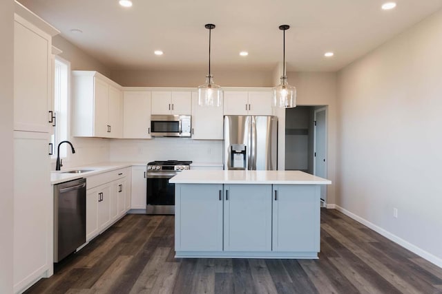 kitchen with pendant lighting, a center island, white cabinets, sink, and stainless steel appliances