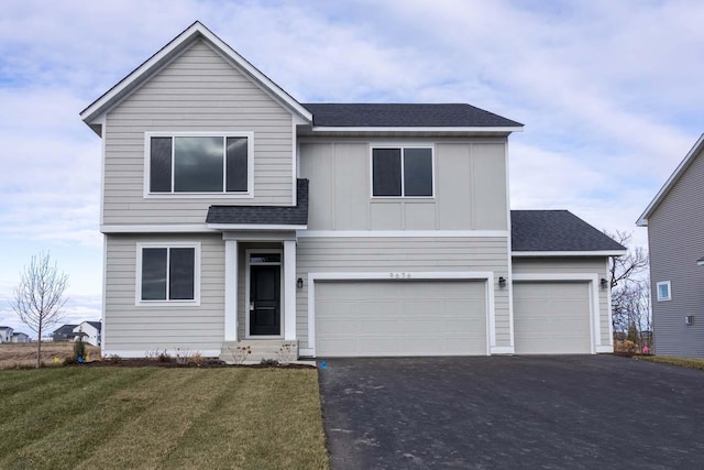 view of front of house with a garage and a front lawn