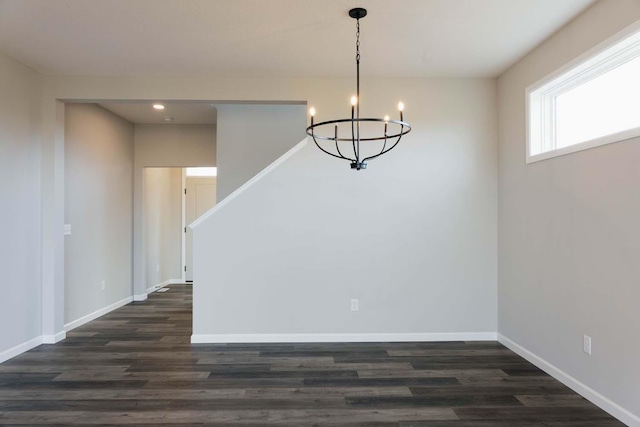 unfurnished dining area with a chandelier and dark hardwood / wood-style floors