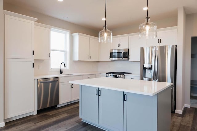 kitchen featuring pendant lighting, a kitchen island, white cabinetry, and appliances with stainless steel finishes