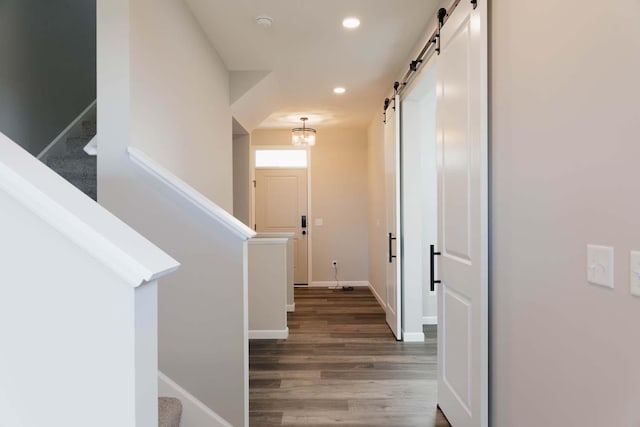 hall with a barn door and dark hardwood / wood-style flooring