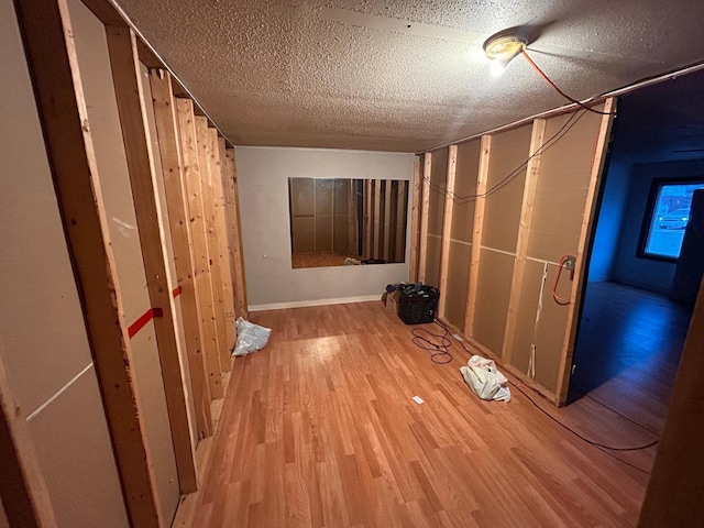 basement featuring hardwood / wood-style floors and a textured ceiling