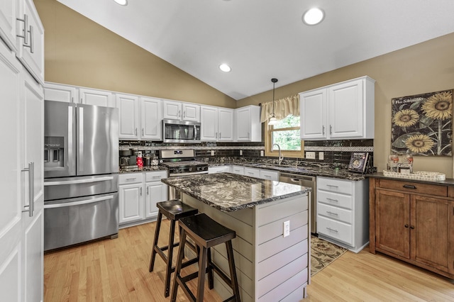 2567 Bridle Creek Trl, Chanhassen, MN 55317 - kitchen featuring stainless steel appliances, lofted ceiling, tasteful backsplash, dark stone countertops, and light wood-style flooring