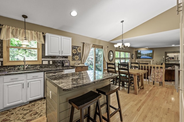 2567 Bridle Creek Trl, Chanhassen, MN 55317 - kitchen featuring light wood-type flooring, lofted ceiling, a chandelier, white cabinets, and dark stone counters