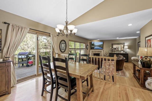 2567 Bridle Creek Trl, Chanhassen, MN 55317 - dining space featuring vaulted ceiling, light wood-style flooring, a chandelier, a fireplace, and recessed lighting