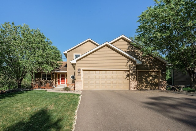 2567 Bridle Creek Trl, Chanhassen, MN 55317 - view of front facade with brick siding, an attached garage, asphalt driveway, a front lawn, and covered porch