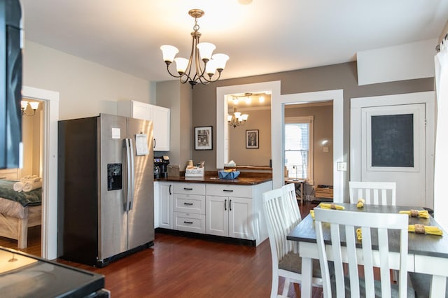 kitchen with pendant lighting, dark wood-type flooring, white cabinets, stainless steel fridge with ice dispenser, and a chandelier