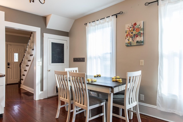 dining room featuring lofted ceiling and dark wood-type flooring