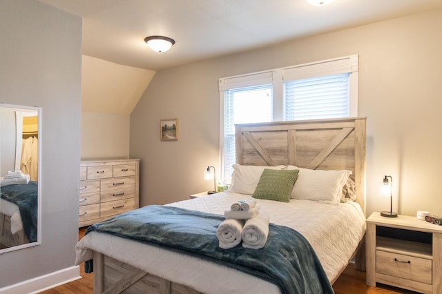 bedroom with lofted ceiling and dark wood-type flooring