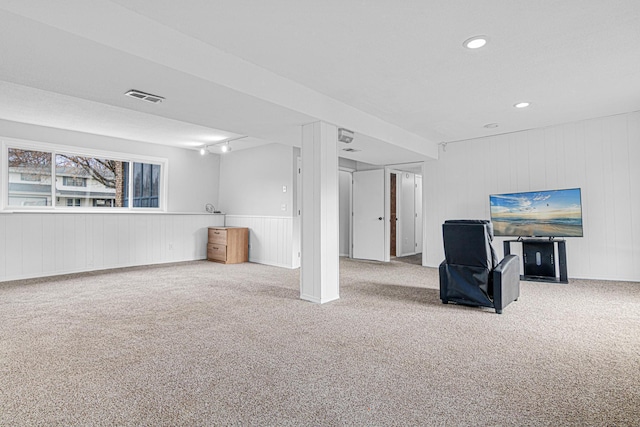 basement featuring carpet flooring and wood walls