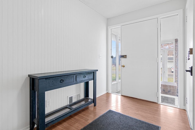 foyer featuring wooden walls and wood-type flooring