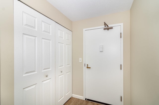 entryway with wood-type flooring and a textured ceiling