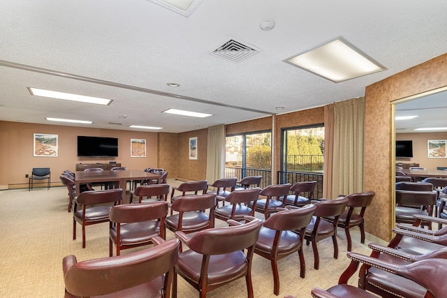 dining area with a textured ceiling and light carpet