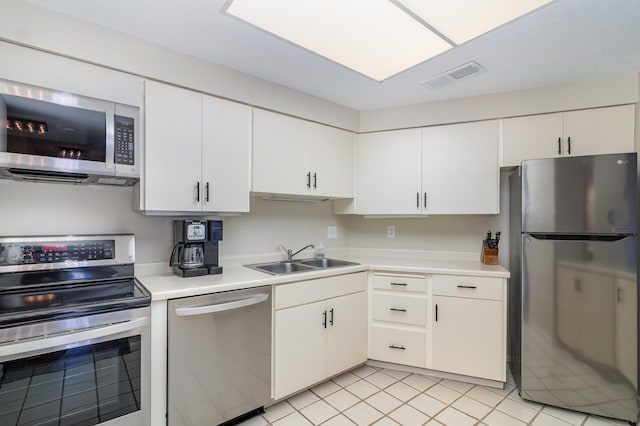 kitchen with visible vents, appliances with stainless steel finishes, light countertops, and a sink