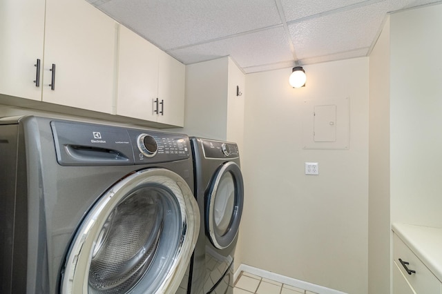 laundry room with light tile patterned floors, baseboards, cabinet space, and washing machine and clothes dryer