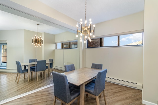 dining space with a notable chandelier, a baseboard heating unit, and wood finished floors