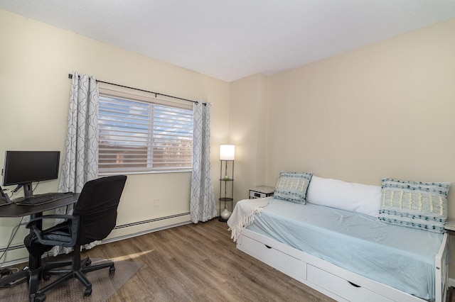 bedroom with wood finished floors and a baseboard radiator