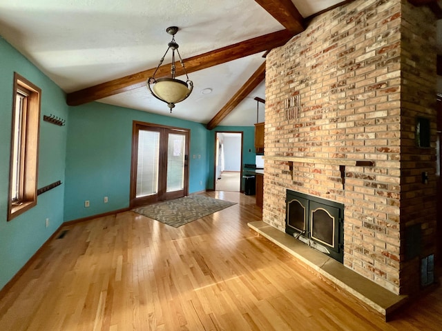 unfurnished living room with vaulted ceiling with beams and hardwood / wood-style flooring