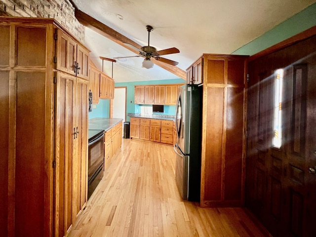 kitchen with vaulted ceiling with beams, light wood-type flooring, stainless steel appliances, and ceiling fan