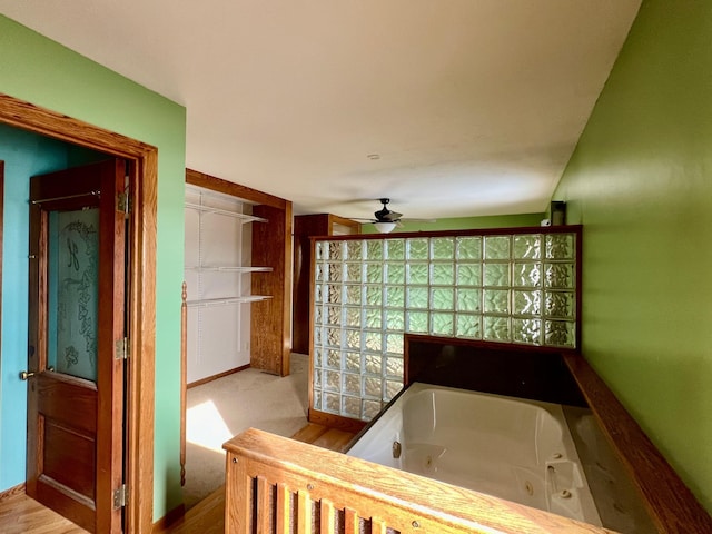 bathroom featuring a tub, ceiling fan, and wood-type flooring