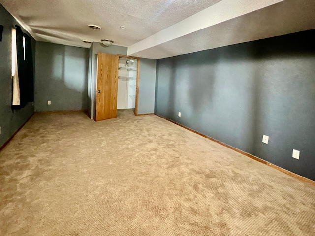 basement featuring light colored carpet and a textured ceiling