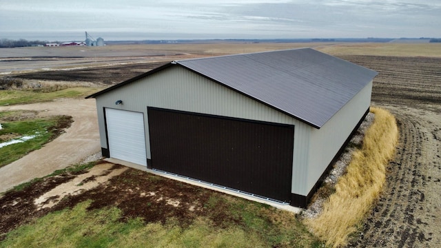 view of outbuilding with a rural view and a garage