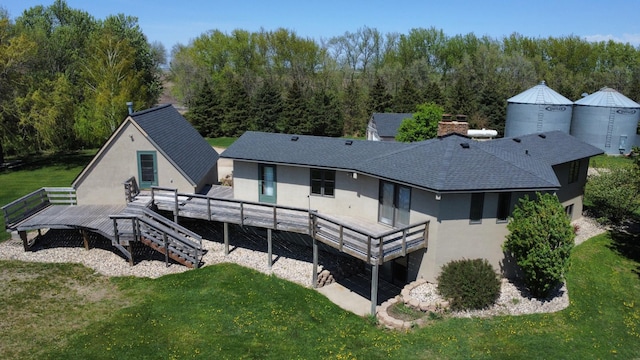 64345 370th St, Ortonville, MN 56278 - rear view of house with a wooden deck, a shingled roof, stucco siding, and a yard
