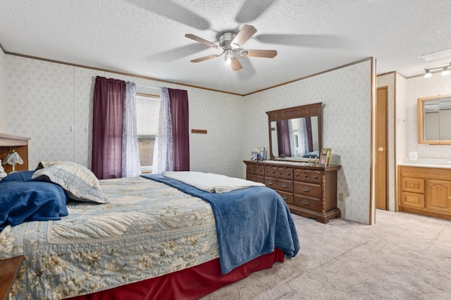 carpeted bedroom with ensuite bath, ceiling fan, crown molding, and a textured ceiling