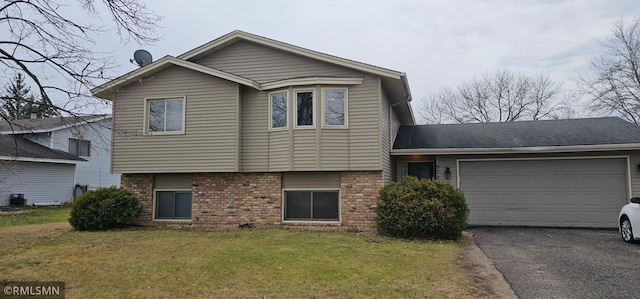 9725 Thomas Ave N, Brooklyn Park, MN 55444 - tri-level home with driveway, an attached garage, brick siding, and a front yard