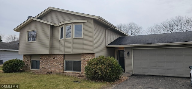 9725 Thomas Ave N, Brooklyn Park, MN 55444 - view of front of home featuring a garage, driveway, brick siding, and a front yard