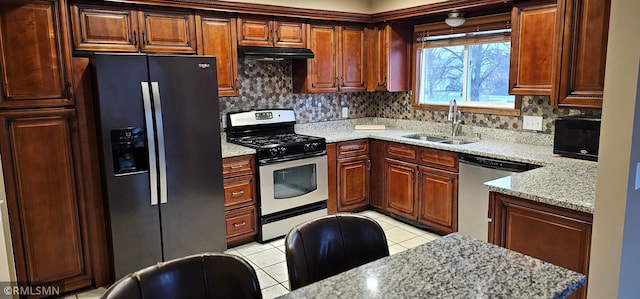 9725 Thomas Ave N, Brooklyn Park, MN 55444 - kitchen with stainless steel appliances, under cabinet range hood, light tile patterned flooring, backsplash, and light stone counters