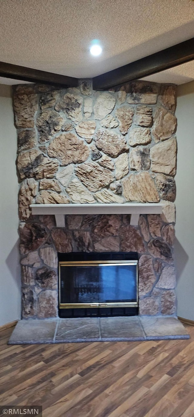 9725 Thomas Ave N, Brooklyn Park, MN 55444 - detailed view of a stone fireplace, a textured ceiling, and wood finished floors