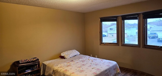 9725 Thomas Ave N, Brooklyn Park, MN 55444 - bedroom featuring dark wood-style flooring and a textured ceiling